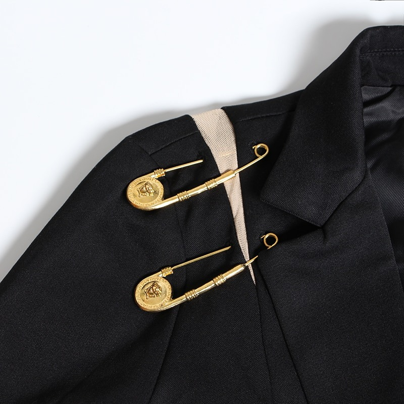 Stylish black women's jacket with unique gold pin accessories on the shoulder for a trendy and sophisticated look.