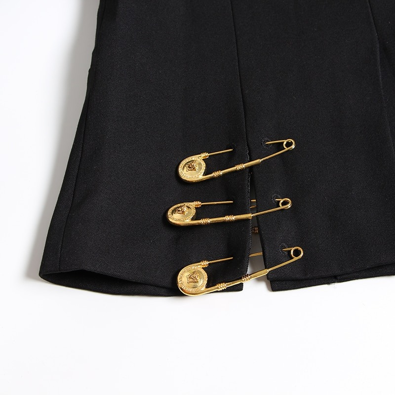 Close-up of a black women's jacket featuring stylish gold pin accessories for a trendy fashion statement.