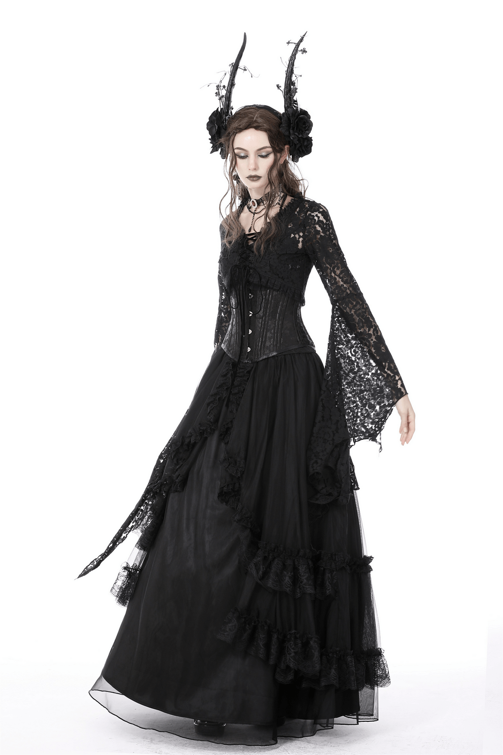 Gothic model in black lace bolero shrug top and long layered skirt, showcasing bell sleeves and dramatic styling.