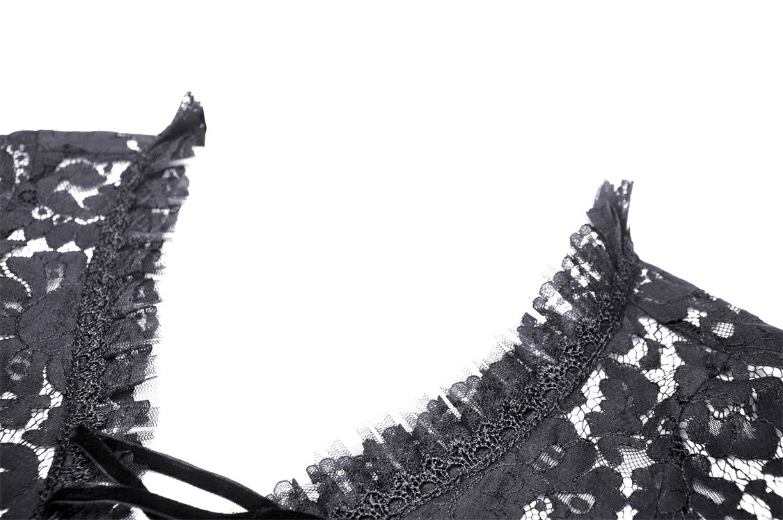 Close-up of black lace fabric with ruffled edges and lace-up detail on a gothic bolero shrug top.