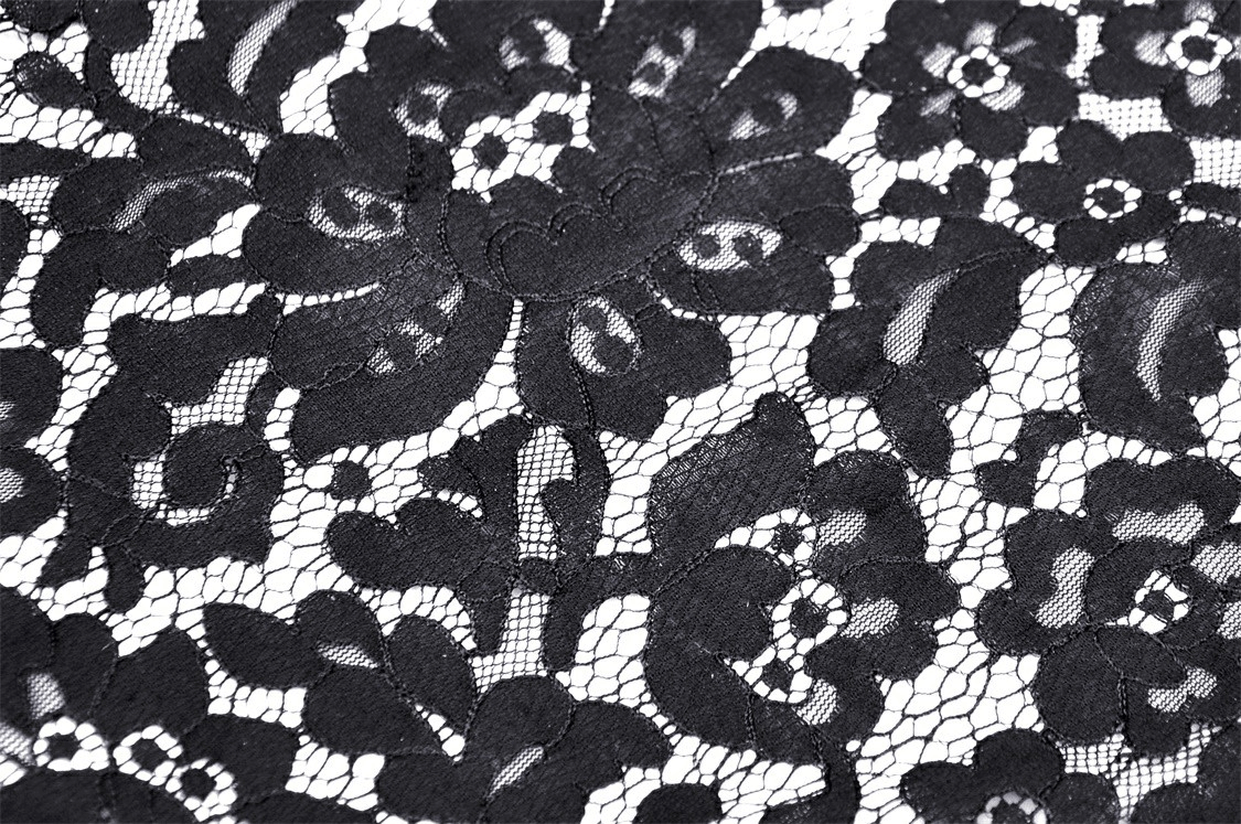 Close-up of intricate black lace fabric with floral patterns, perfect for gothic fashion and stylish layering.