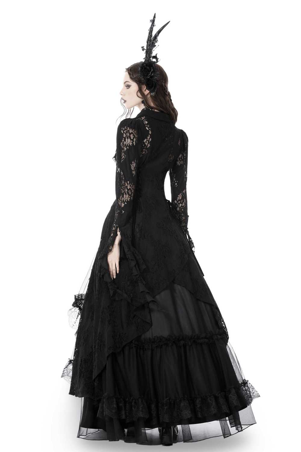 Elegant woman in a black lace gown with an enchanting gothic design, showcasing a dramatic silhouette and layered fabric.