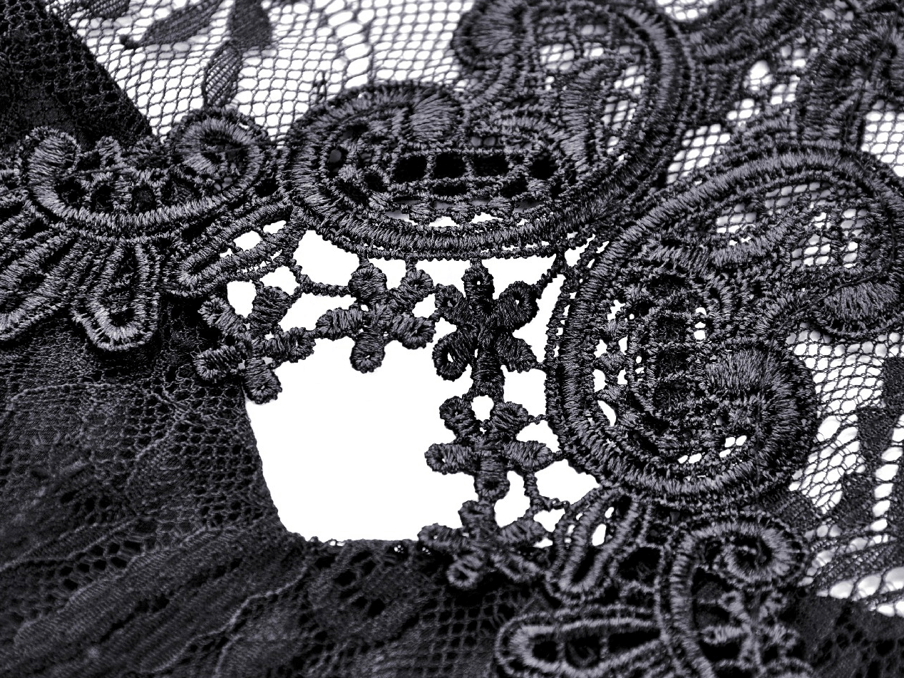 Close-up of intricate black lace fabric showcasing delicate embroidery and patterns for a gothic style dress.