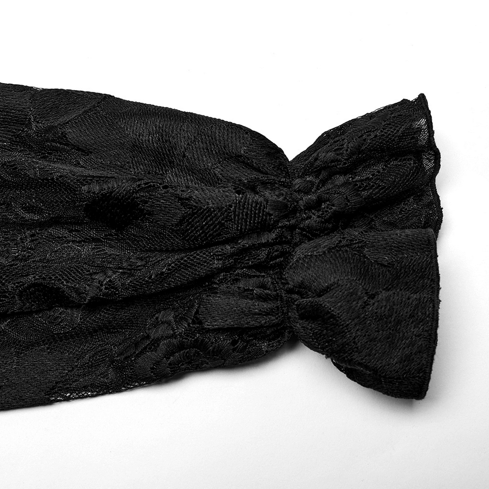 Detail of black lace fabric with ruffled edge, showcasing gothic elegance and intricate embroidery.