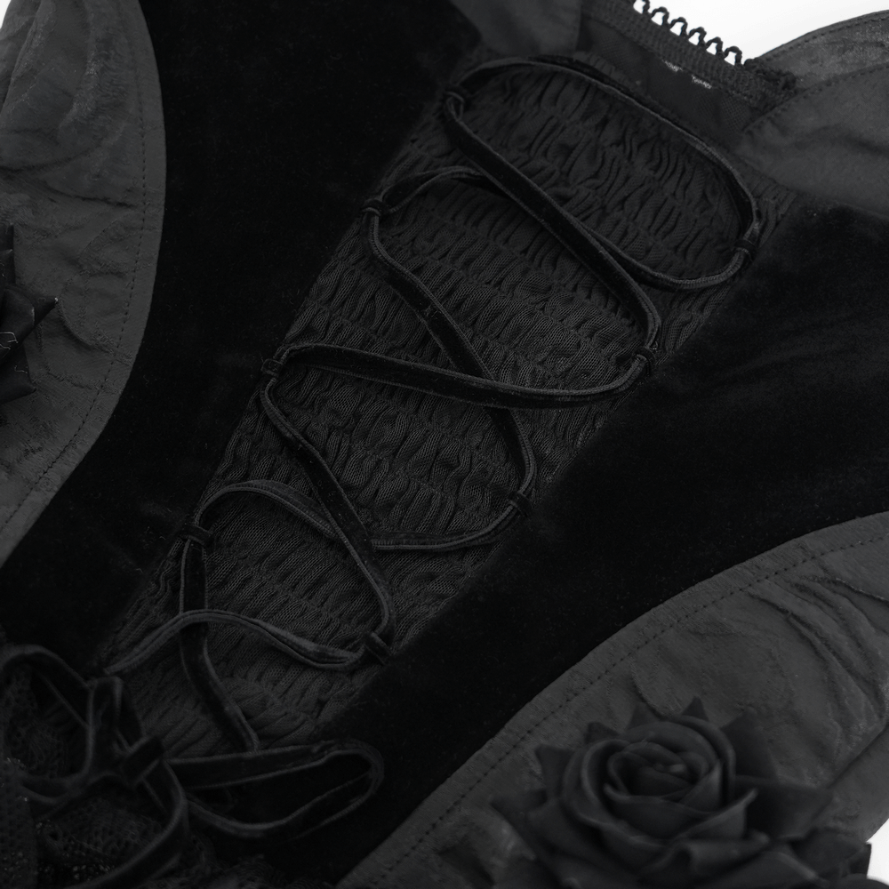 Close-up of elegant black lace top featuring velvet details, lace roses, and intricate lace-up design.