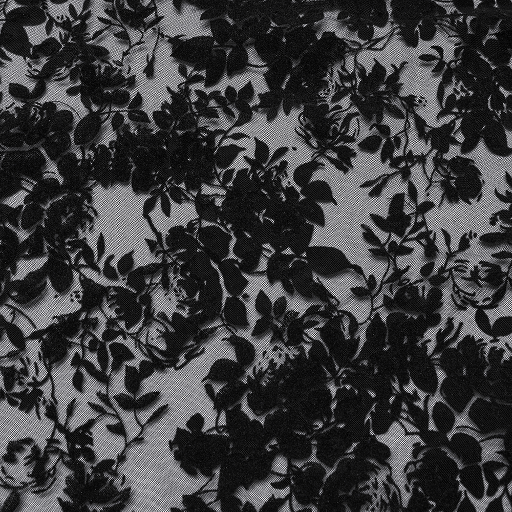 Close-up of black floral lace fabric, showcasing intricate velvet rose patterns for a gothic dress.