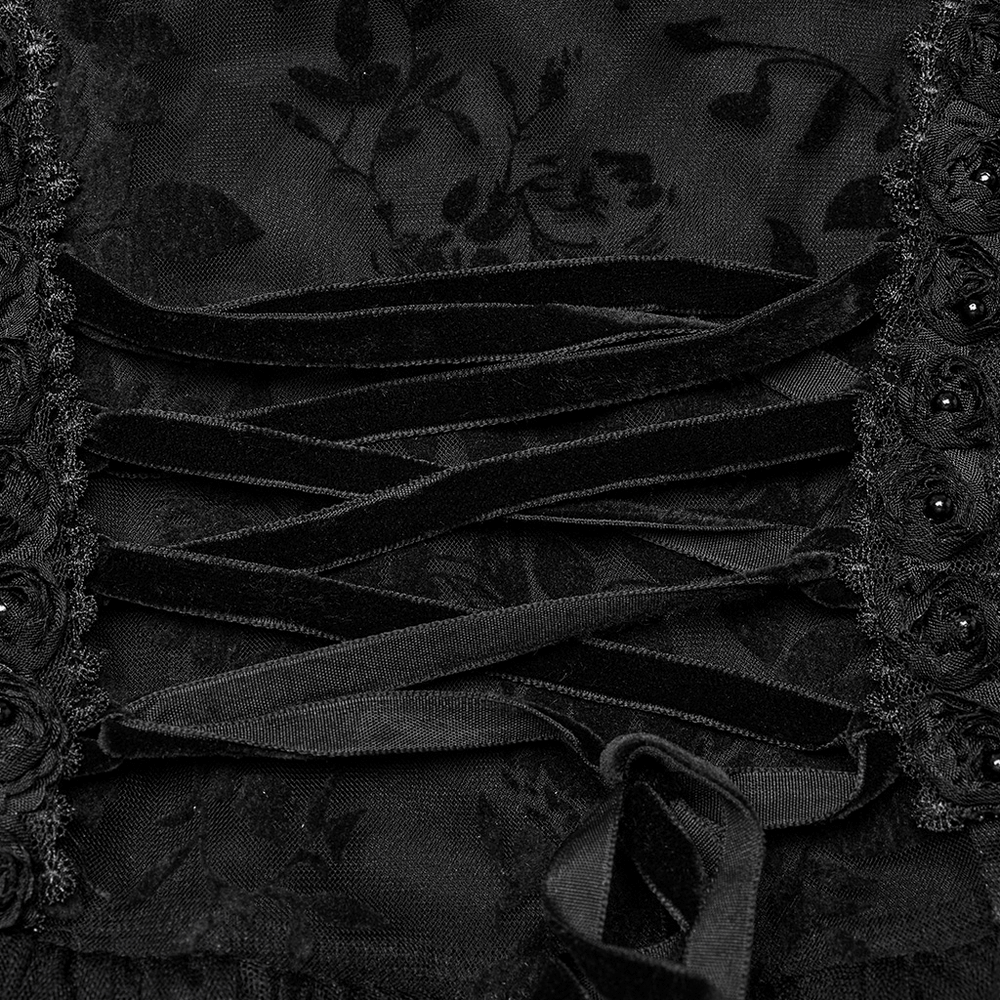 Close-up of black velvet lacing and rose trim on a gothic mesh dress, showcasing intricate detailing and elegant design.
