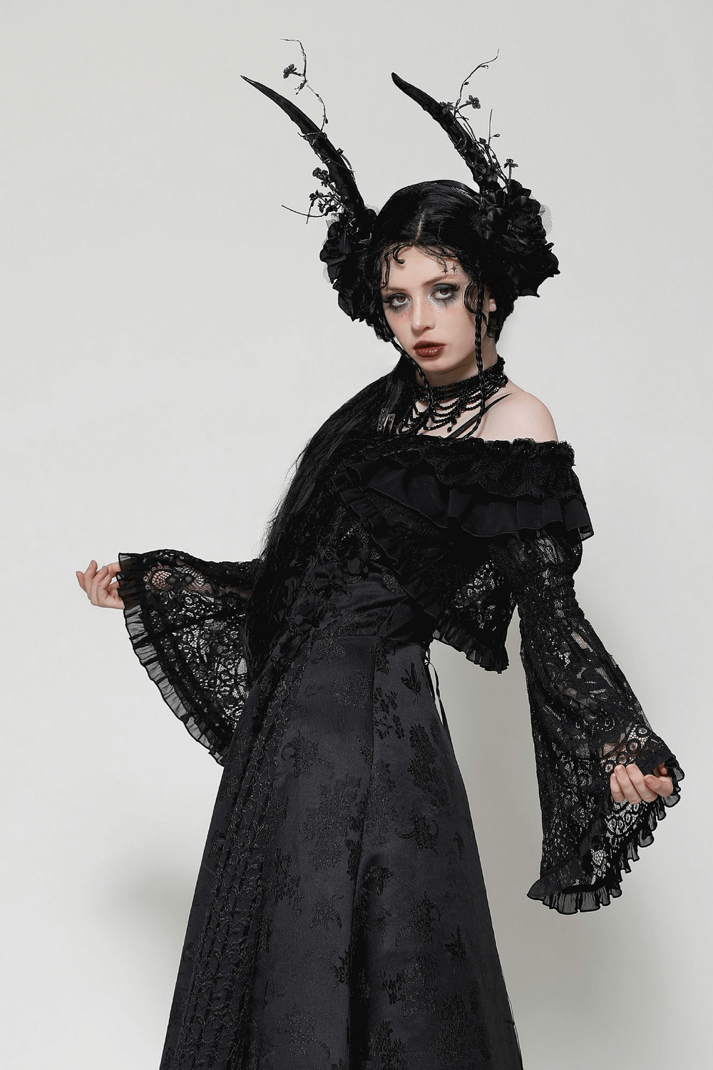 Elegant black lace gothic off-shoulder cape with flared sleeves, styled for a dramatic alternative fashion look.