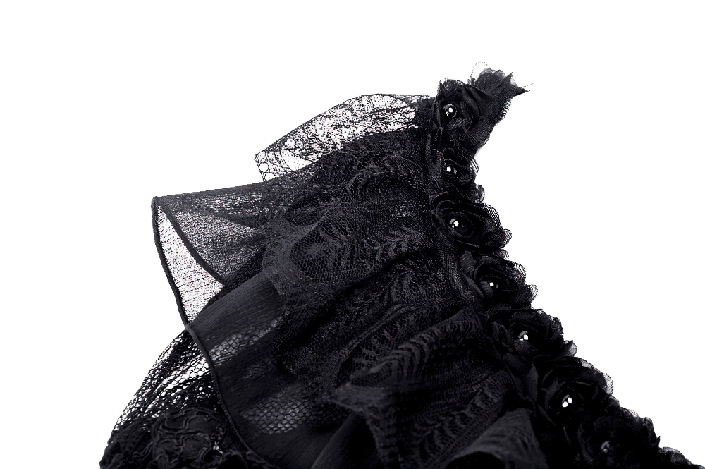 Close-up of black lace cape detailing with ruffles and floral accents, perfect for gothic fashion enthusiasts.