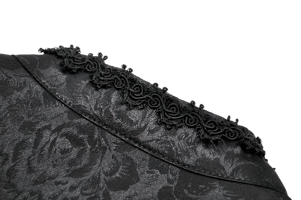 Close-up of black lace detailing on a gothic cape, showcasing elegant frills and intricate embroidery.