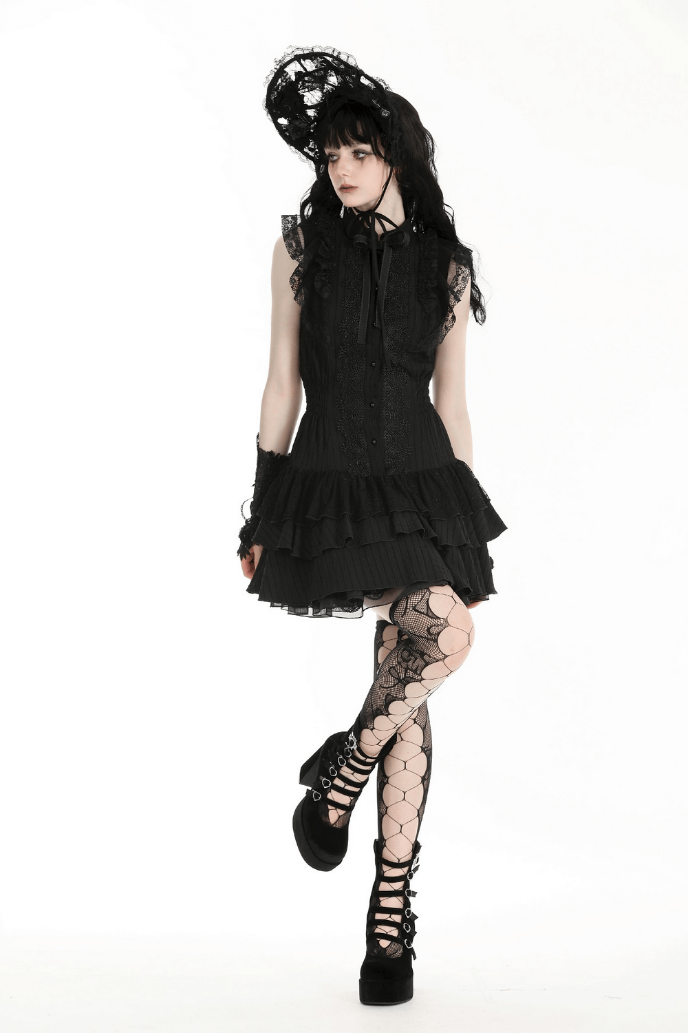 Gothic black lace ruffled dress with ribbon detail worn by model, featuring elegant style and fishnet stockings.
