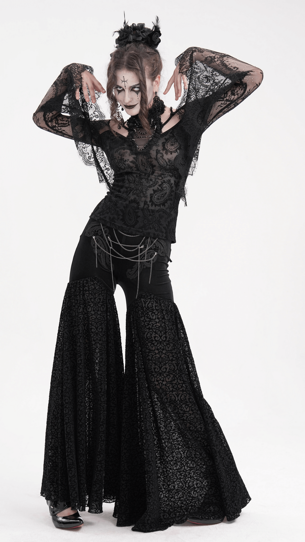 Model wearing a black lace gothic top with bell sleeves and neck chains, styled for a dramatic gothic look.