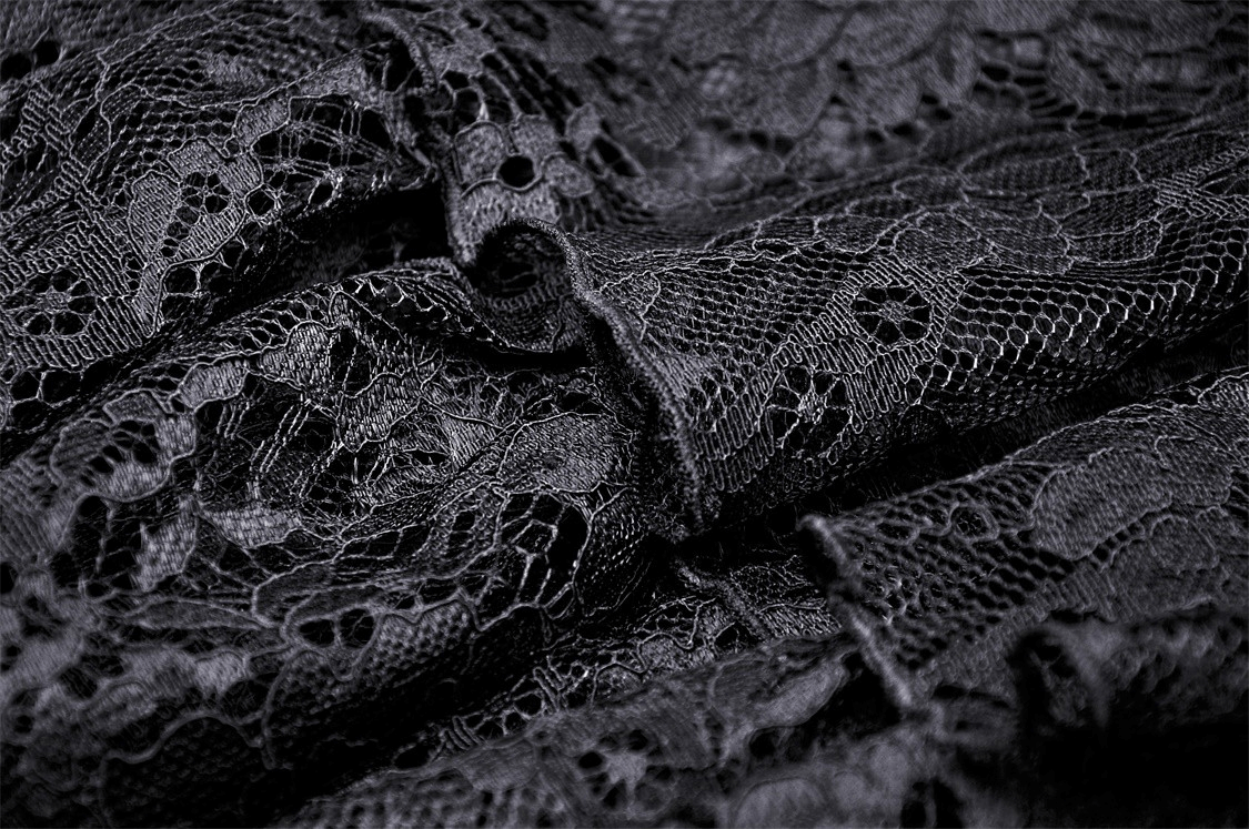 Close-up of intricate black lace fabric featuring floral patterns, perfect for gothic and romantic dress designs.