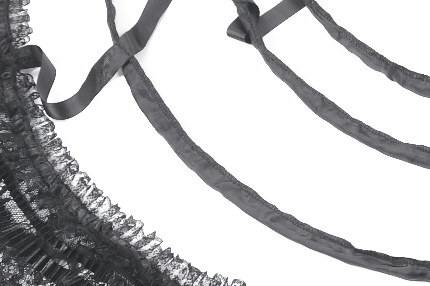 Close-up of black lace and satin ribbons from a gothic high-low petticoat skirt, showcasing intricate detailing.
