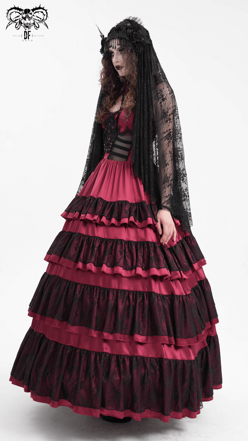 Gothic woman in a black lace long veil and a dramatic red and black layered dress, perfect for dark fashion.
