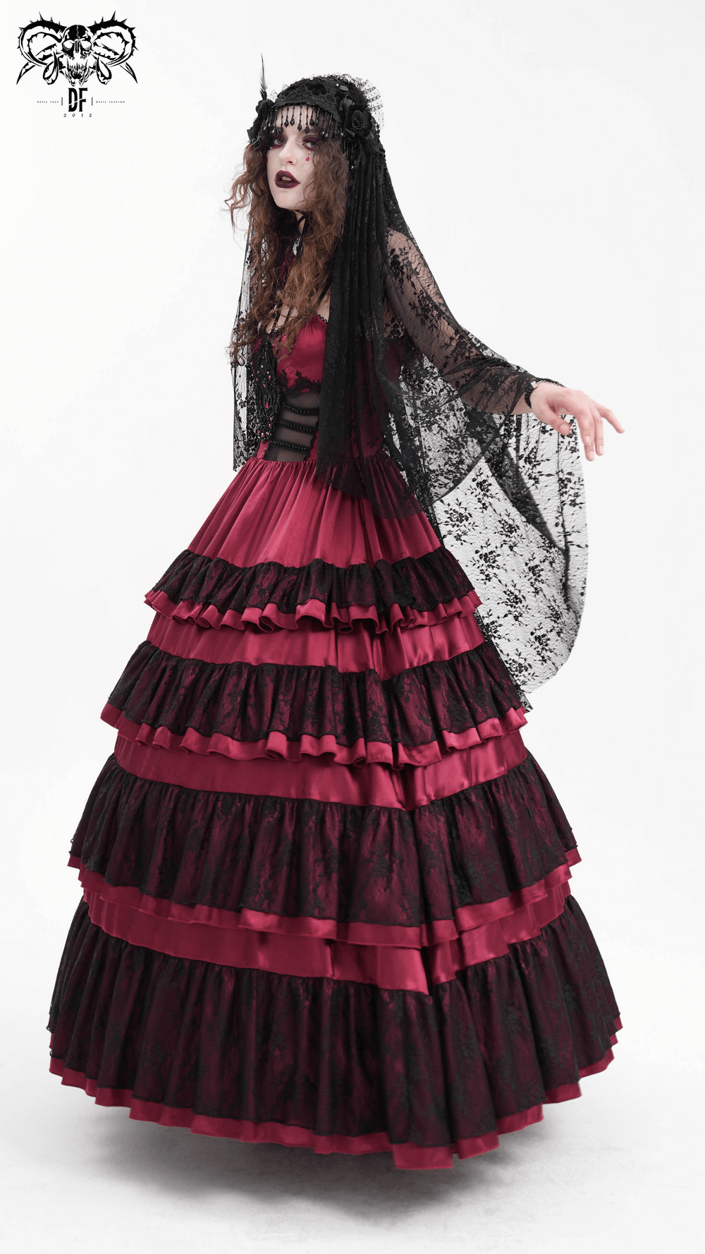 Gothic Lolita model in a black lace veil and a dramatic red and black gown, embracing dark fashion elegance.