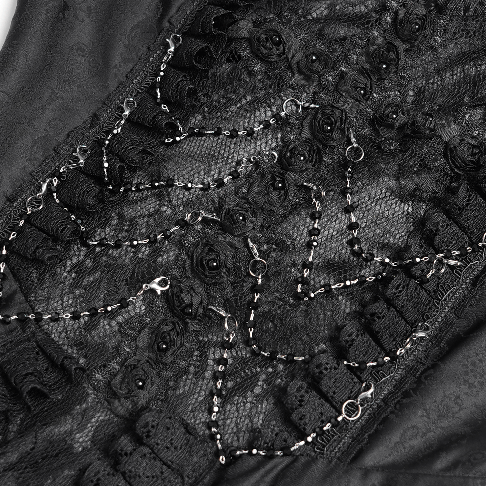 Close-up of black lace details with rose embellishments and decorative chains on a gothic-style dress.