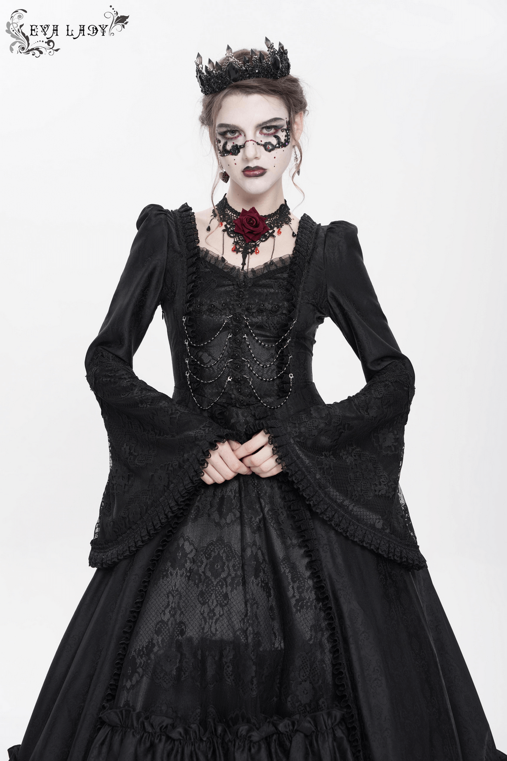 Elegant model in a black lace medieval dress with bell sleeves, corset back, chains, and gothic accessories.