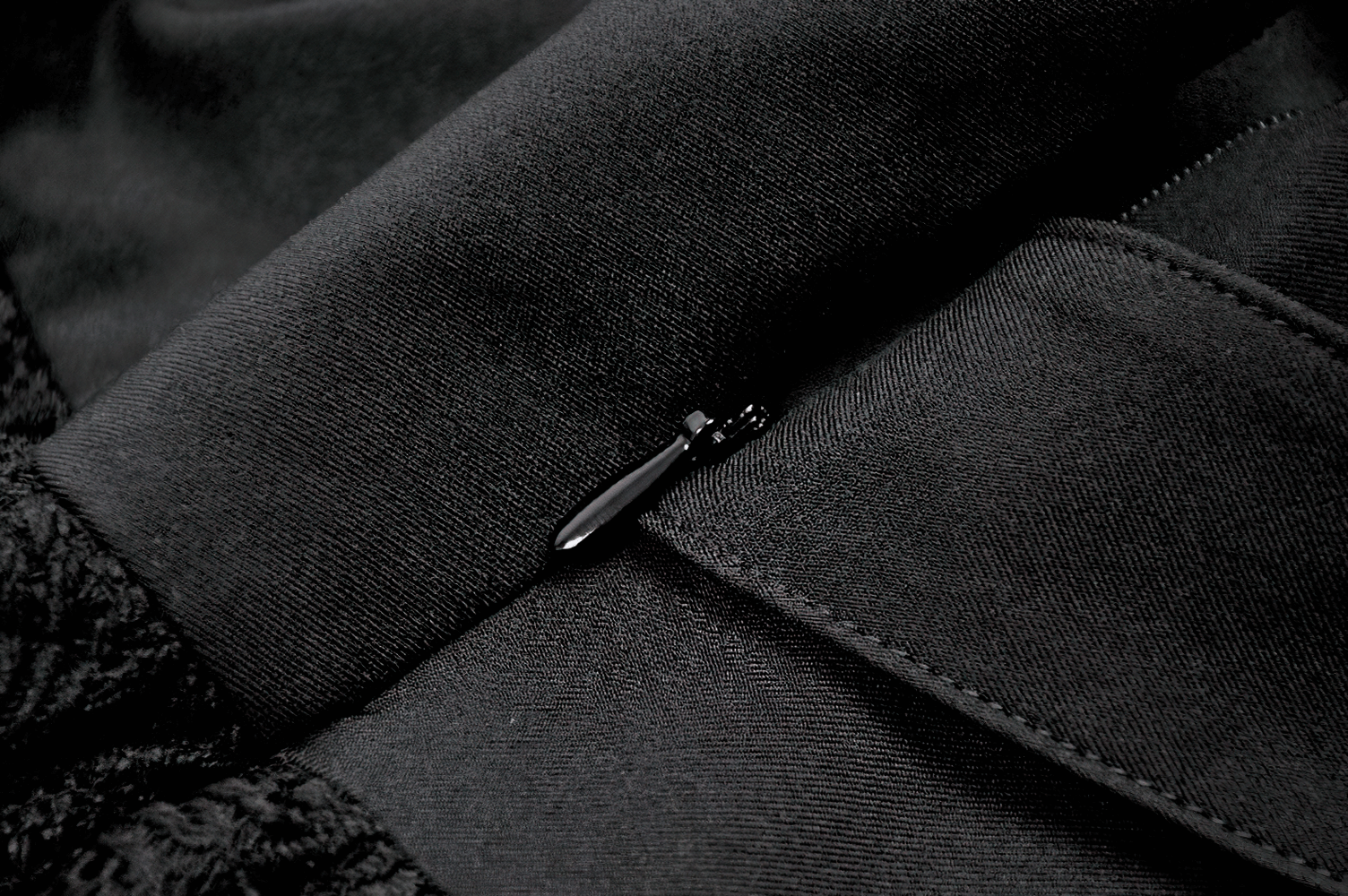 Close-up of the zipper detail on the Black Lace Mini Skirt with Straps and Layered Ruffles, showcasing the luxe material and construction.