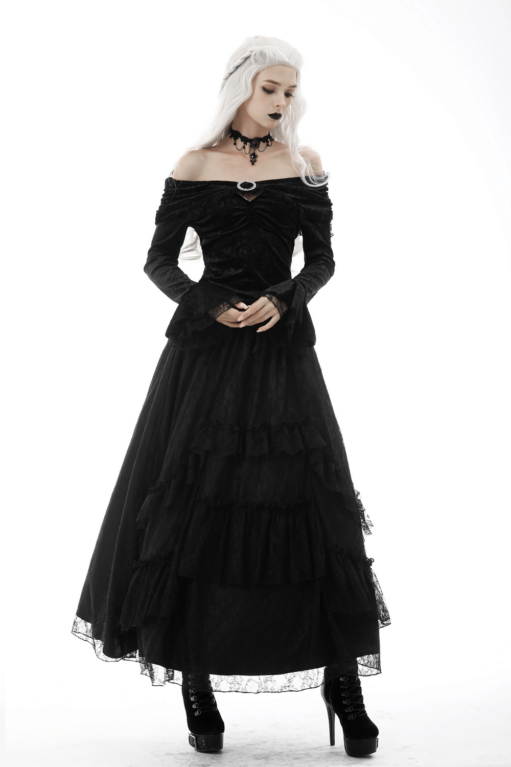 Victorian-inspired black lace off-shoulder top with brooch detail and layered skirt, perfect for gothic fashion.