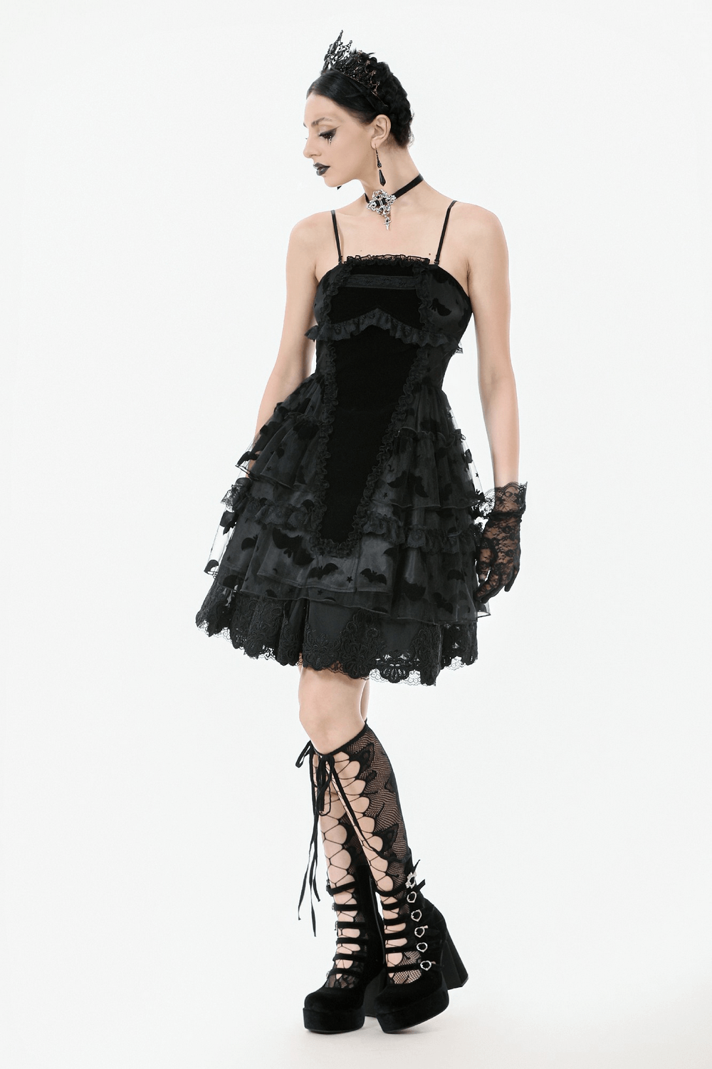 Black gothic dress with ruffles, bat print, and lace-up details, paired with chunky lace-up boots.