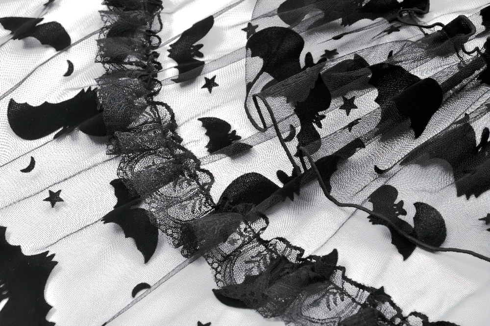 Close-up of black lace ruffled fabric featuring whimsical bat and star print, perfect for a gothic dress.