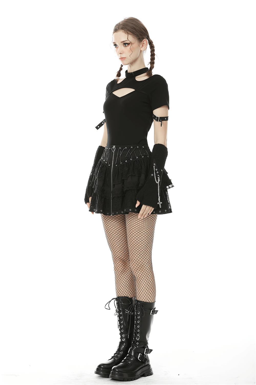 Gothic model in a black cut-out top and ruffled lace skirt, wearing fishnet tights and lace-up boots.