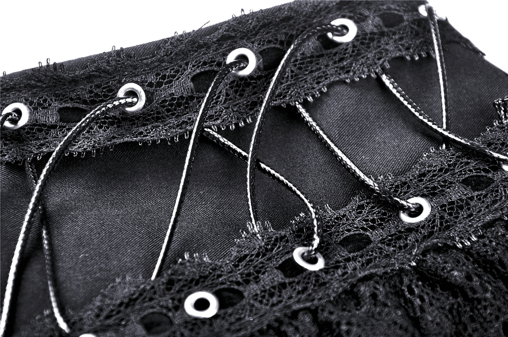Close-up of black lace ruffled skirt featuring heart-shaped lacing and metal grommets for an edgy gothic style.
