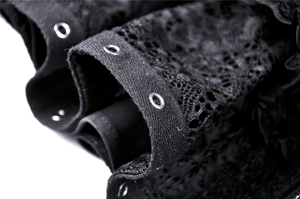 Close-up of black lace ruffled skirt showcasing intricate lace and metal grommets for a gothic style.