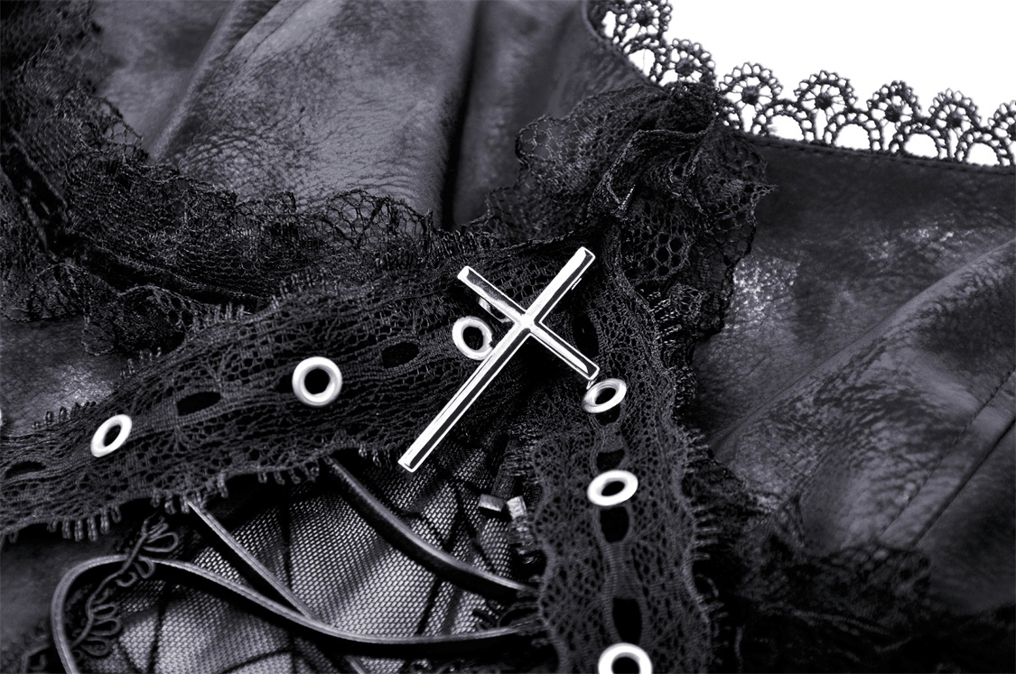 Close-up of black lace with intricate spiderweb design and metallic cross detail on punk suspender dress.