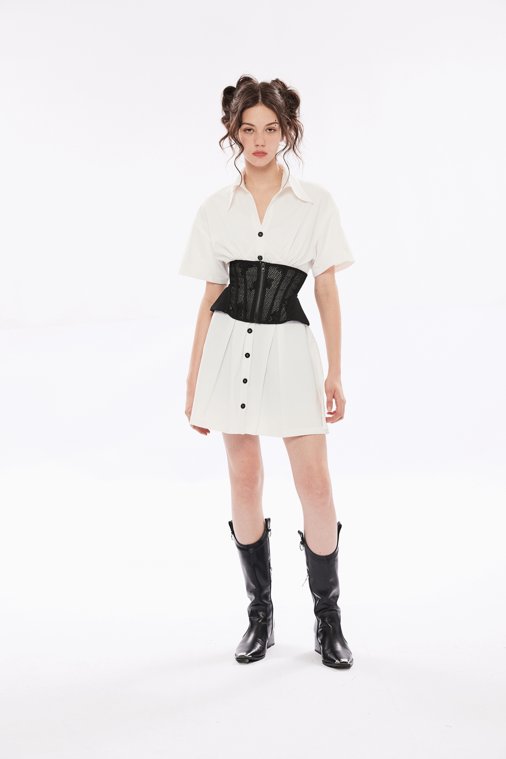 Model wearing a Black Lace-Up Cincher Corset with Mesh Panels over a white dress and black knee-high boots.