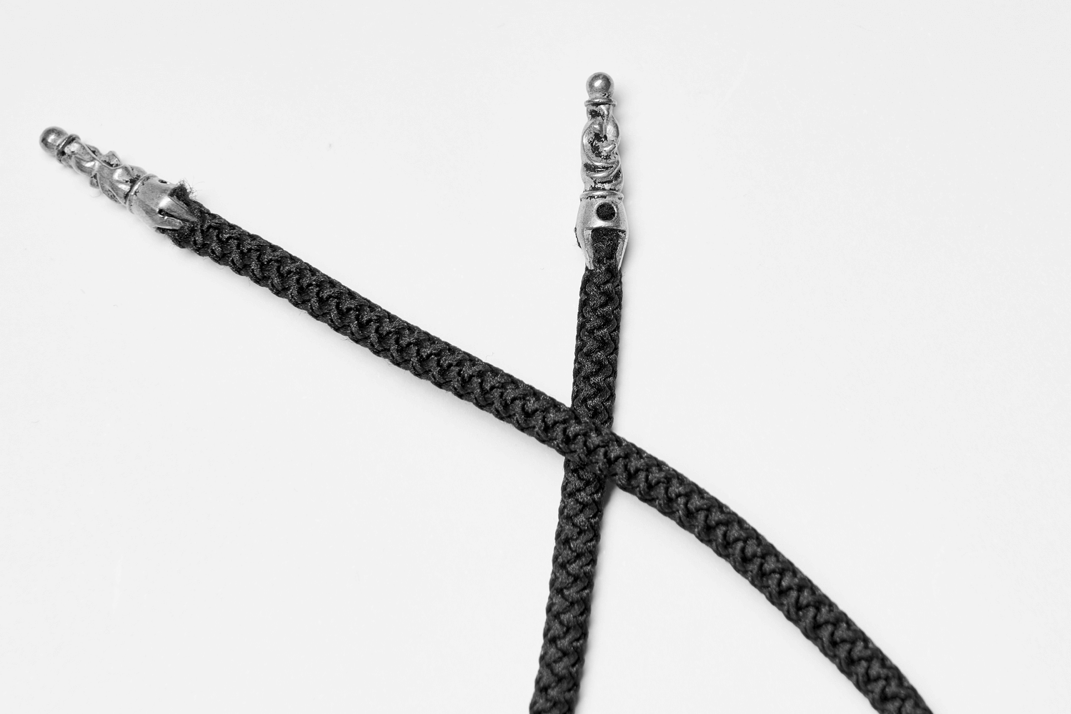 Close-up of black braided cord with metal tips, ideal for corsets or accessories.