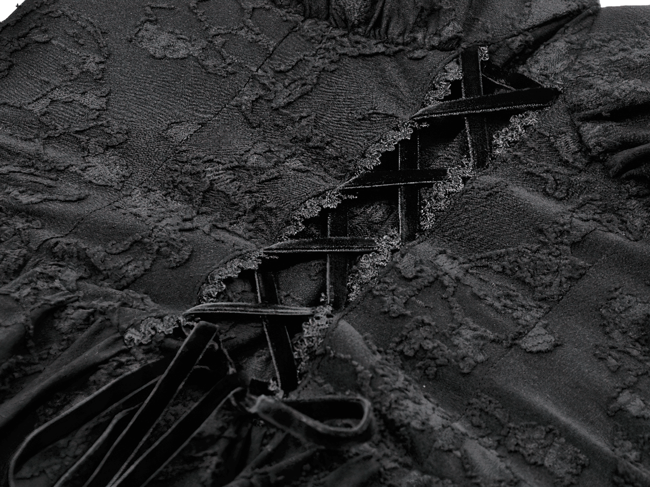 Close-up of the black lace detailing and corset-style lace-up feature of the Black Lace-Up Gothic Mini Dress with Bell Sleeves.