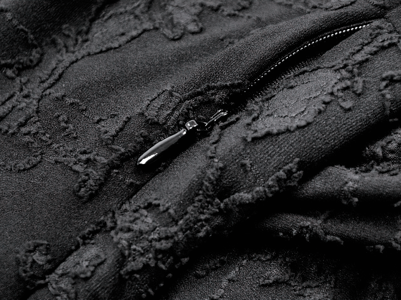 Close-up of black lace fabric with a zipper, showcasing details on the Black Lace-Up Gothic Mini Dress with Bell Sleeves.