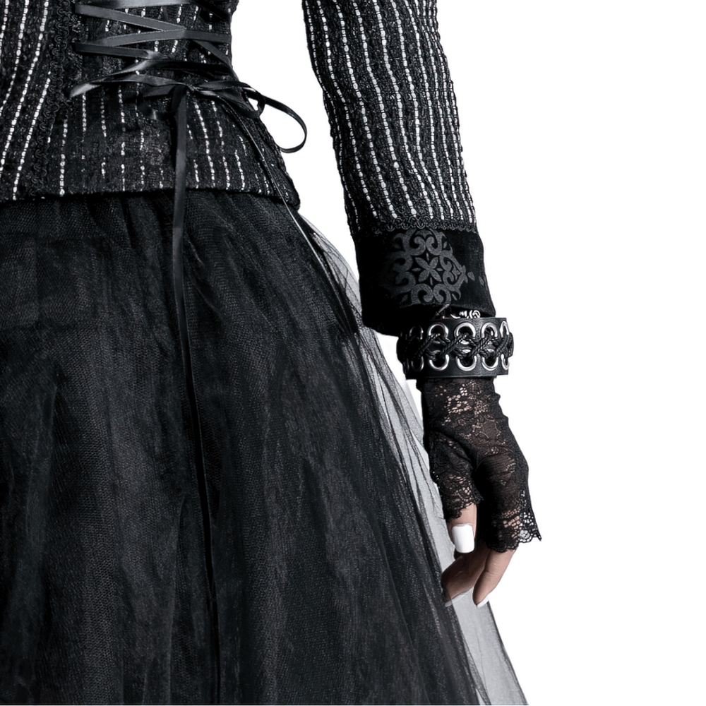 Close-up of elegant black lace Victorian-inspired fashion gloves paired with a stylish black outfit.