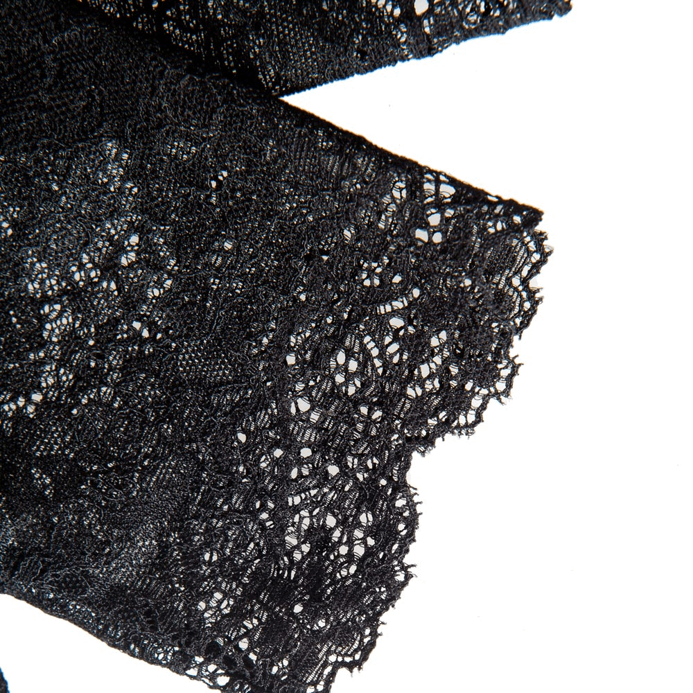Close-up of elegant black lace detailing on Victorian-inspired fashion gloves, showcasing intricate patterns.