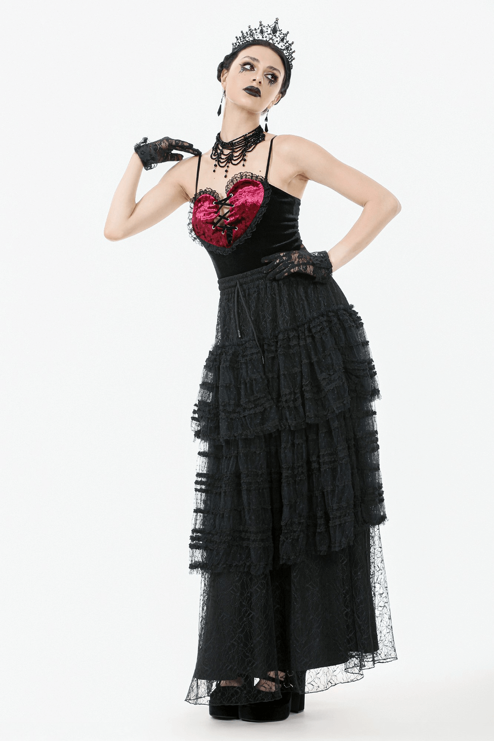 Gothic woman in layered black lace maxi skirt with drawstring waist, paired with a heart motif top and accessories.