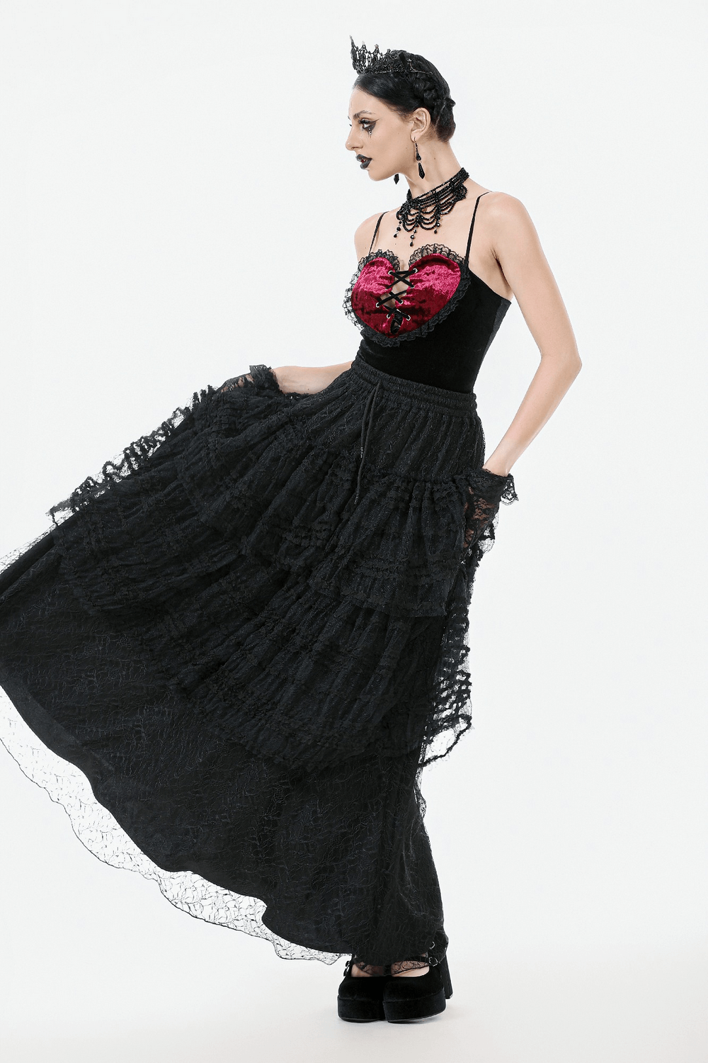 Woman in a black layered lace goth maxi skirt with ruffled tiers, styled for a Victorian-inspired look.