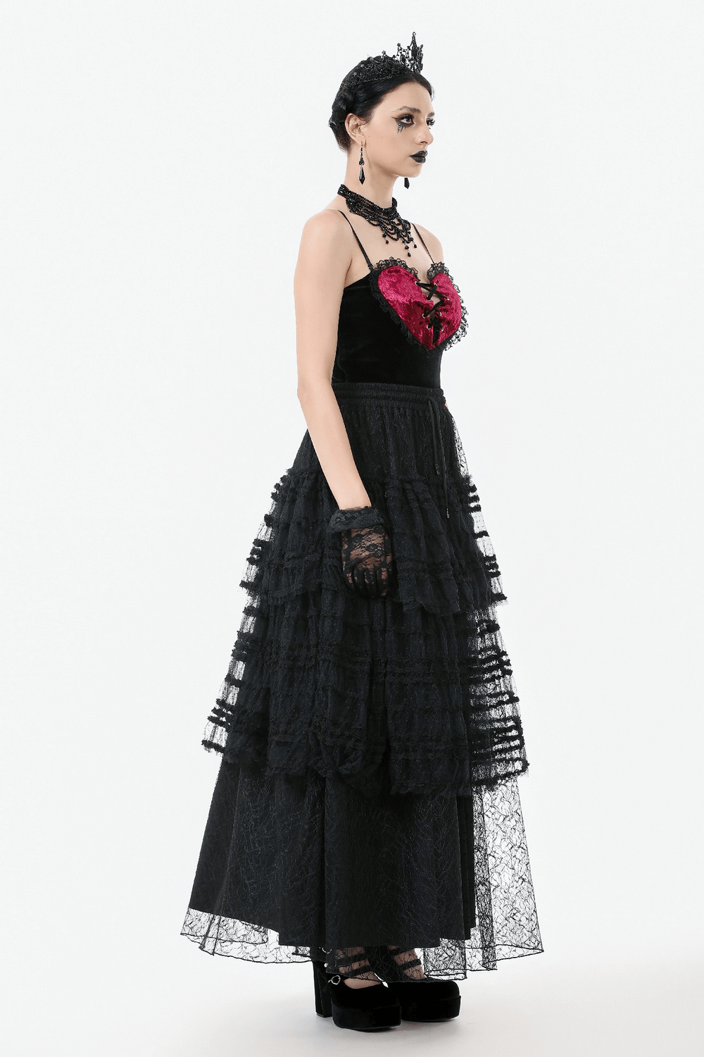 Gothic woman in layered black lace maxi skirt with drawstring waist and heart detail corset top.