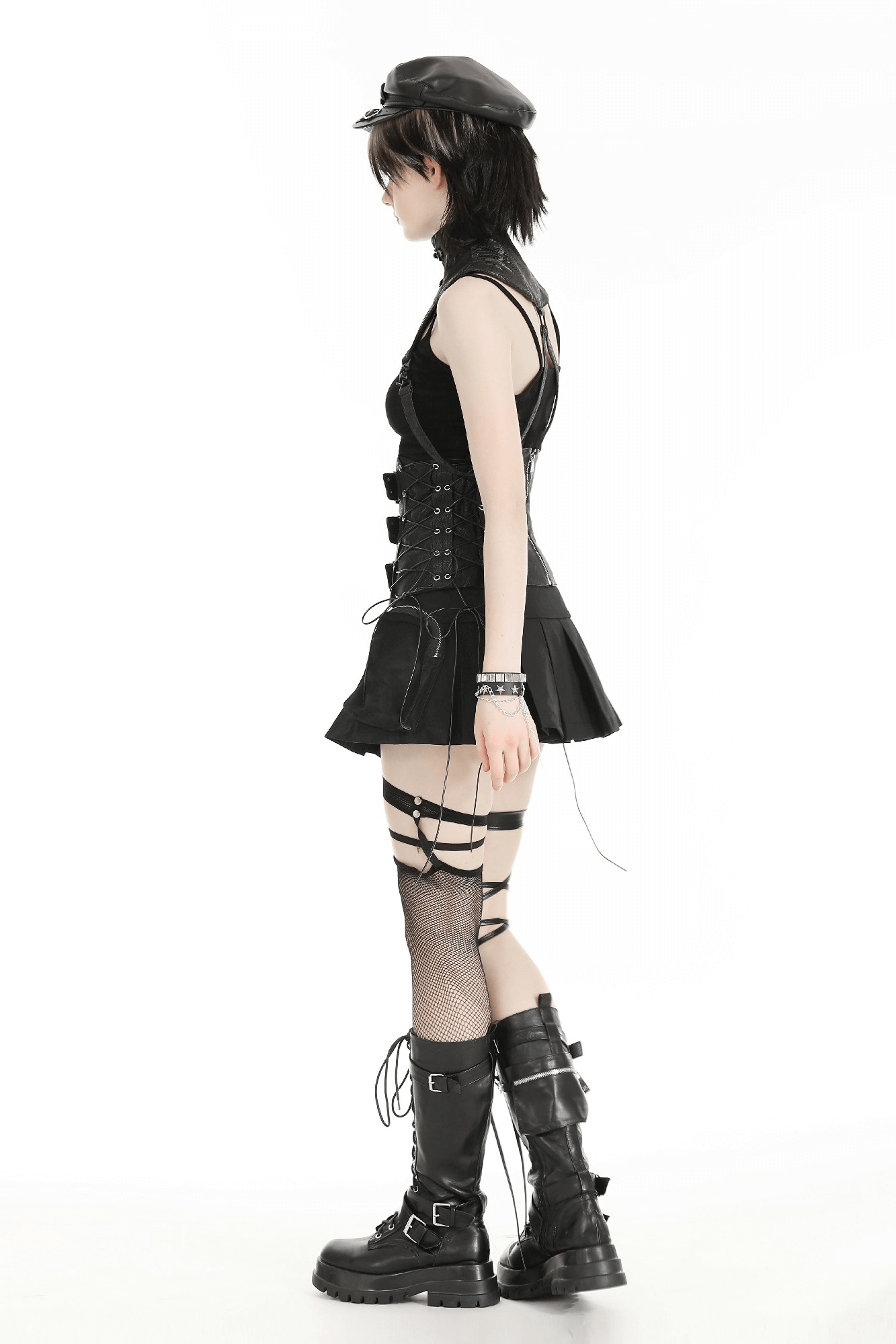 Stylish model showcasing edgy black fashion with a high-neck collar, mini skirt, fishnets, and bold boots.