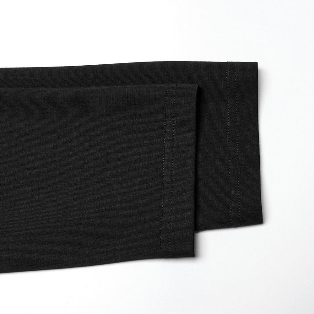 Close-up of the sleek black fabric sleeves from a stylish long-sleeved top with a smooth texture.