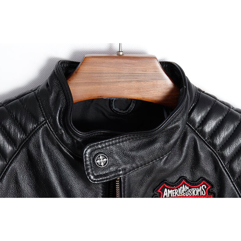 Close-up of the collar and leather detailing on a black men's motorcycle jacket with a vintage patch.