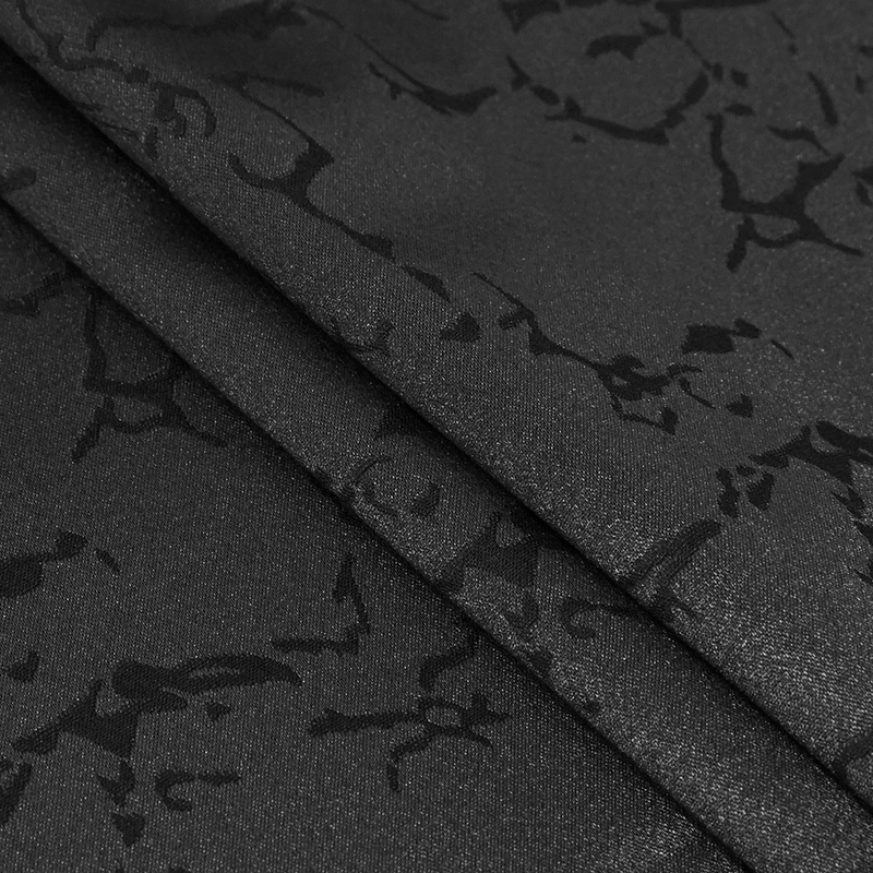 Close-up view of luxurious black fabric with a unique gothic pattern, perfect for vintage-style clothing.