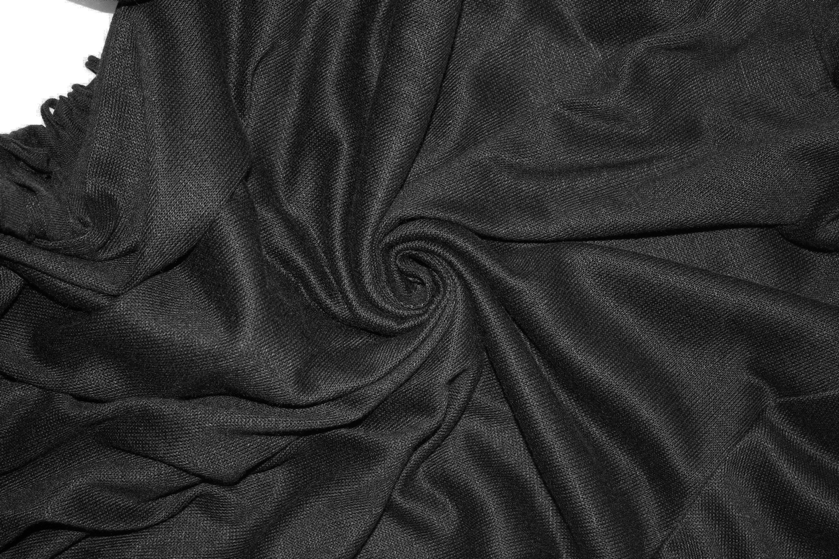 Close-up of soft black fabric swirling in a stylish pattern, perfect for punk gothic fashion.