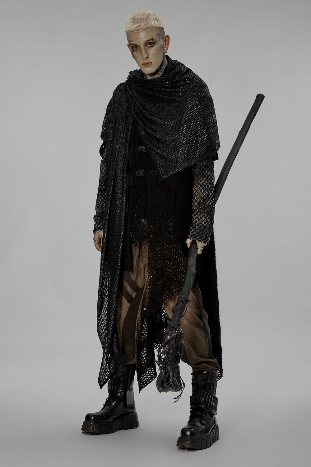 Edgy model in black mesh hooded scarf and futuristic attire, embodying post-apocalyptic festival fashion.