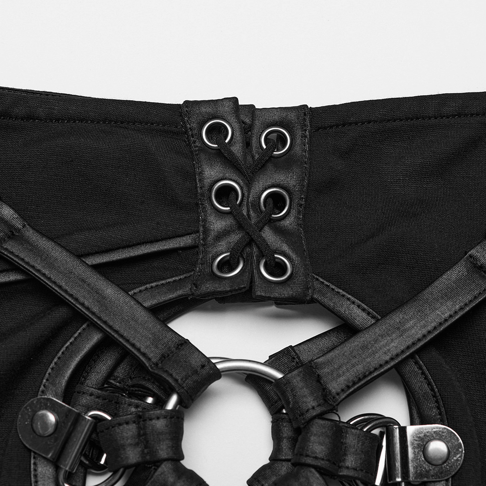 Close-up of black mesh inlay with lace-up detail and metal accents for gothic skinny pants.