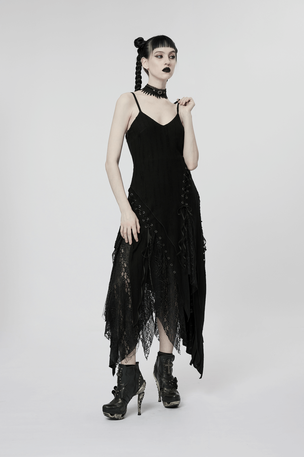 Model in black mesh lace asymmetrical pointed gothic dress with edgy hem and ankle boots, showcasing a bold gothic style.