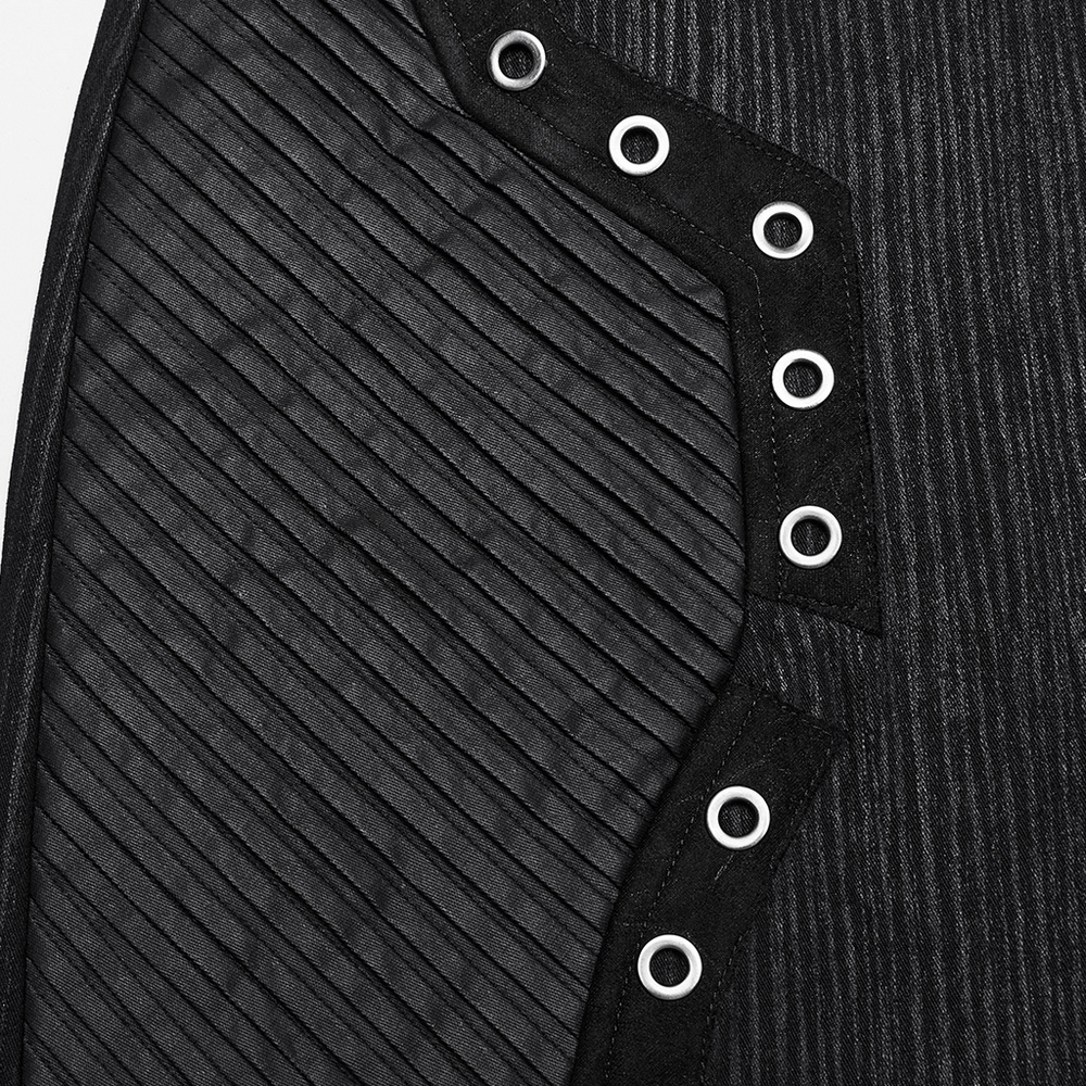 Close-up of black mini skirt with rubberized leather panels and eyelets, featuring 3D pleated design.