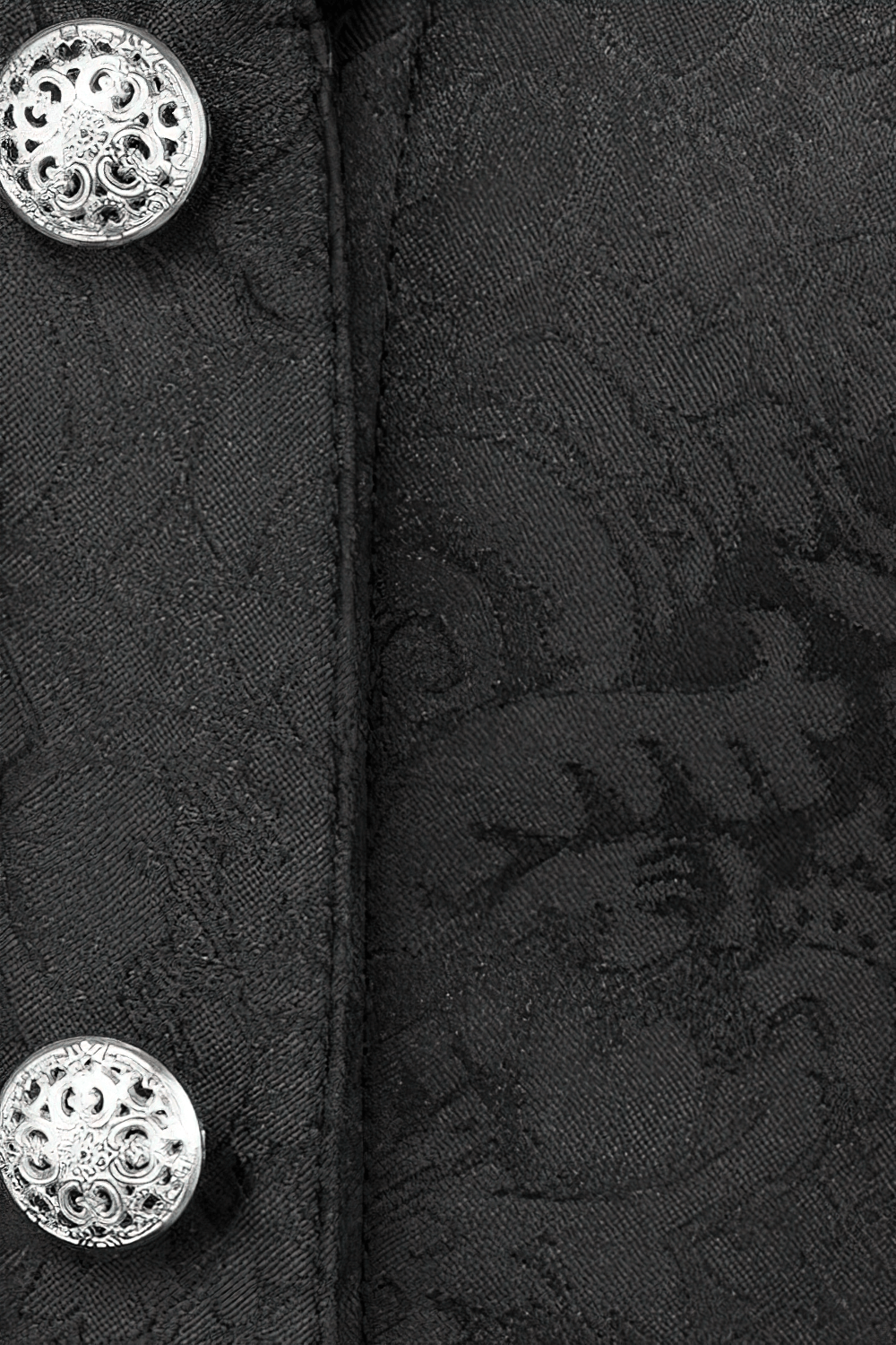 Close-up of black brocade fabric with ornate silver buttons, showcasing gothic corset detail.