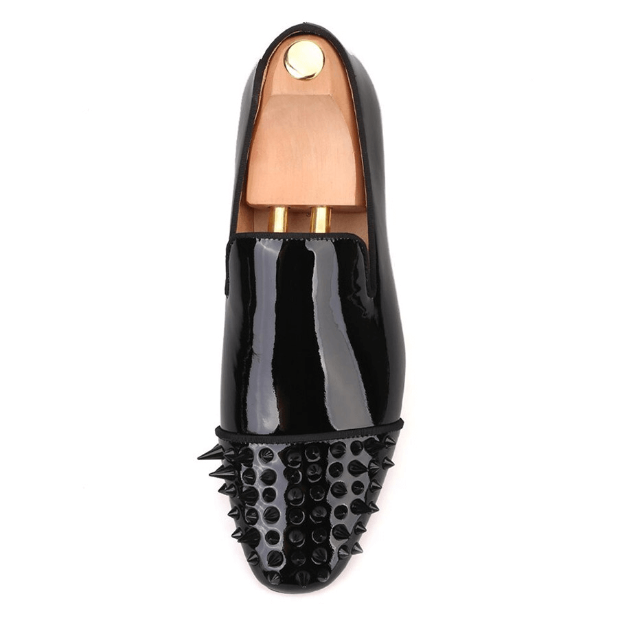 Top view of black patent leather men's loafers with spikes on toe, stylish fashion casual shoes.